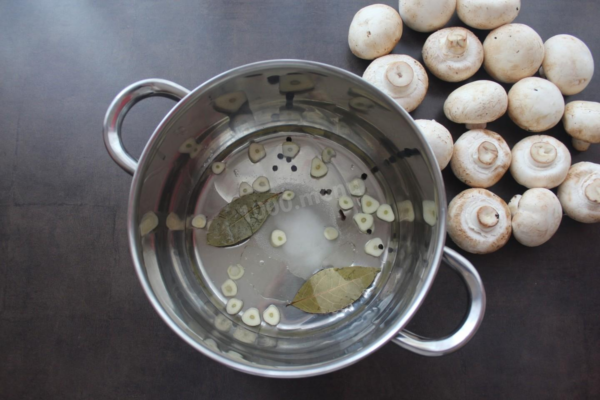 Первым шагом необходимо подготовить будущий маринад. Для этого в кастрюлю наливаем воду и столовый 9% уксус, всыпаем соль и сахар, кладем перец горошком, гвоздику и лавровый лист, выкладываем чеснок, предварительно разрезав его зубчики небольшими пластинками, и вливаем растительное масло.