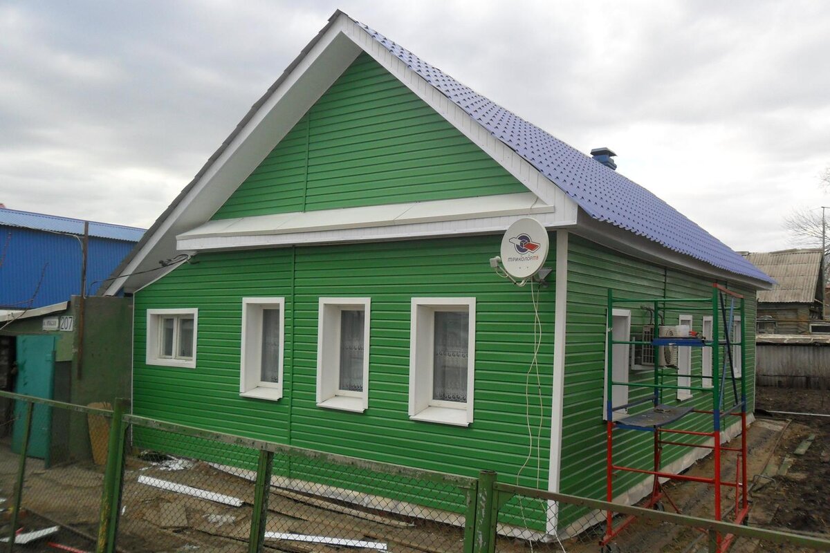 Обшитый сайдингом дом с пластиковыми окнами