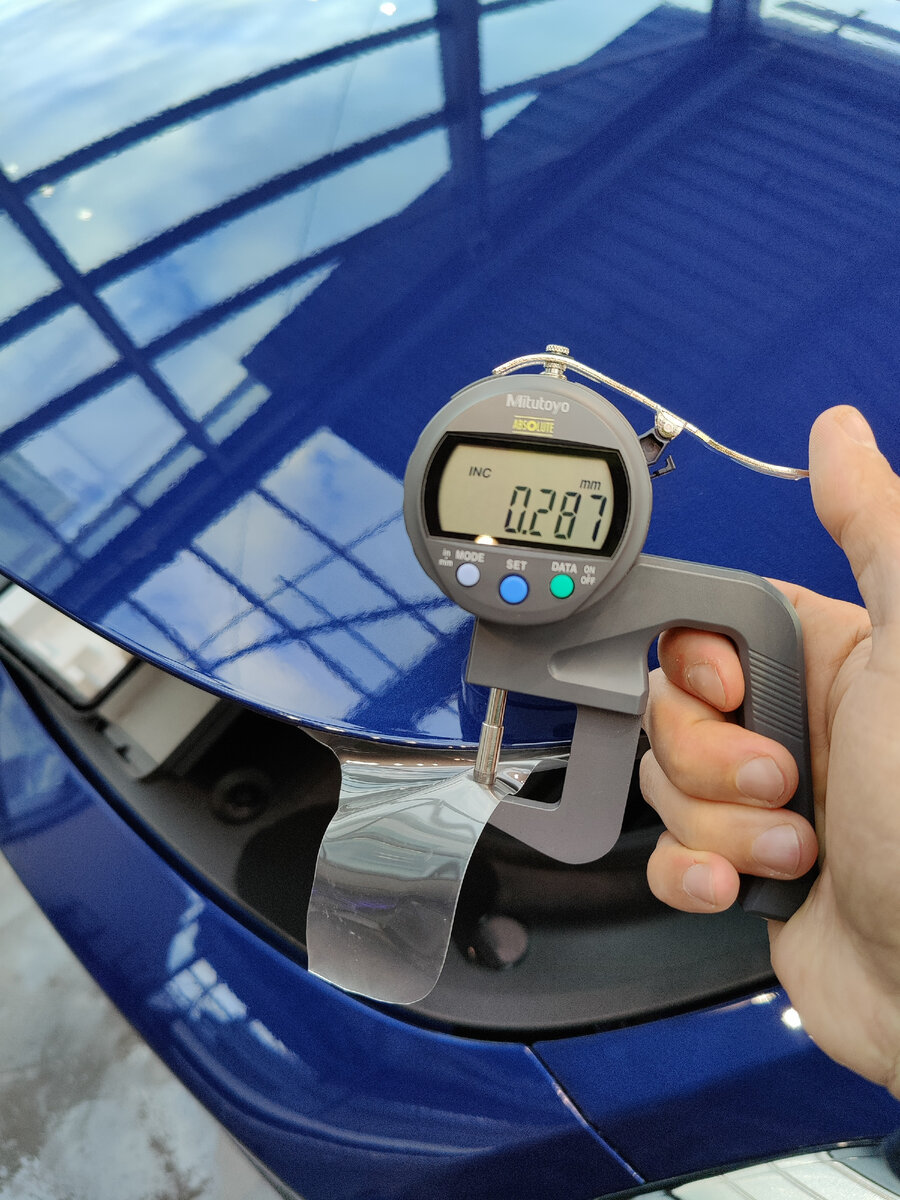 В работе Tesla model Y. На фото замер толщины пленке на капоте, пред тем как окончательно подвернуть пленку.