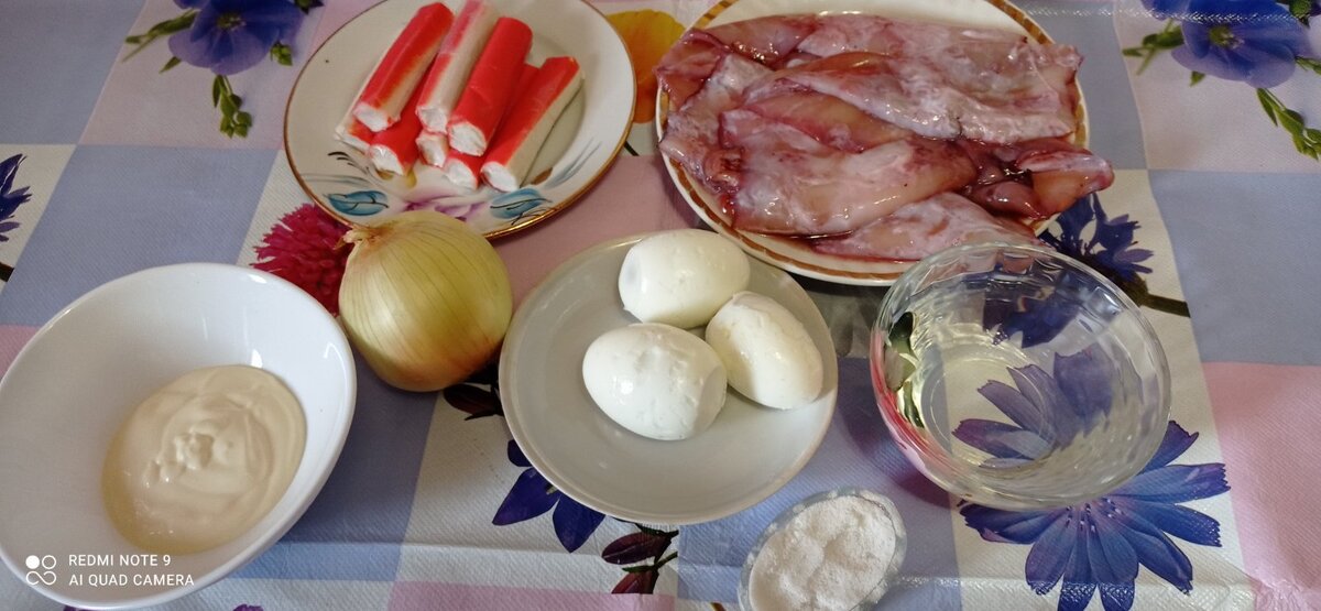 Для салатика потребуется: полкилограмма замороженных кальмаров, 100 г палочек или мяса краба, 3 заранее сваренных яичка, уксус, майонез, лук и соль.