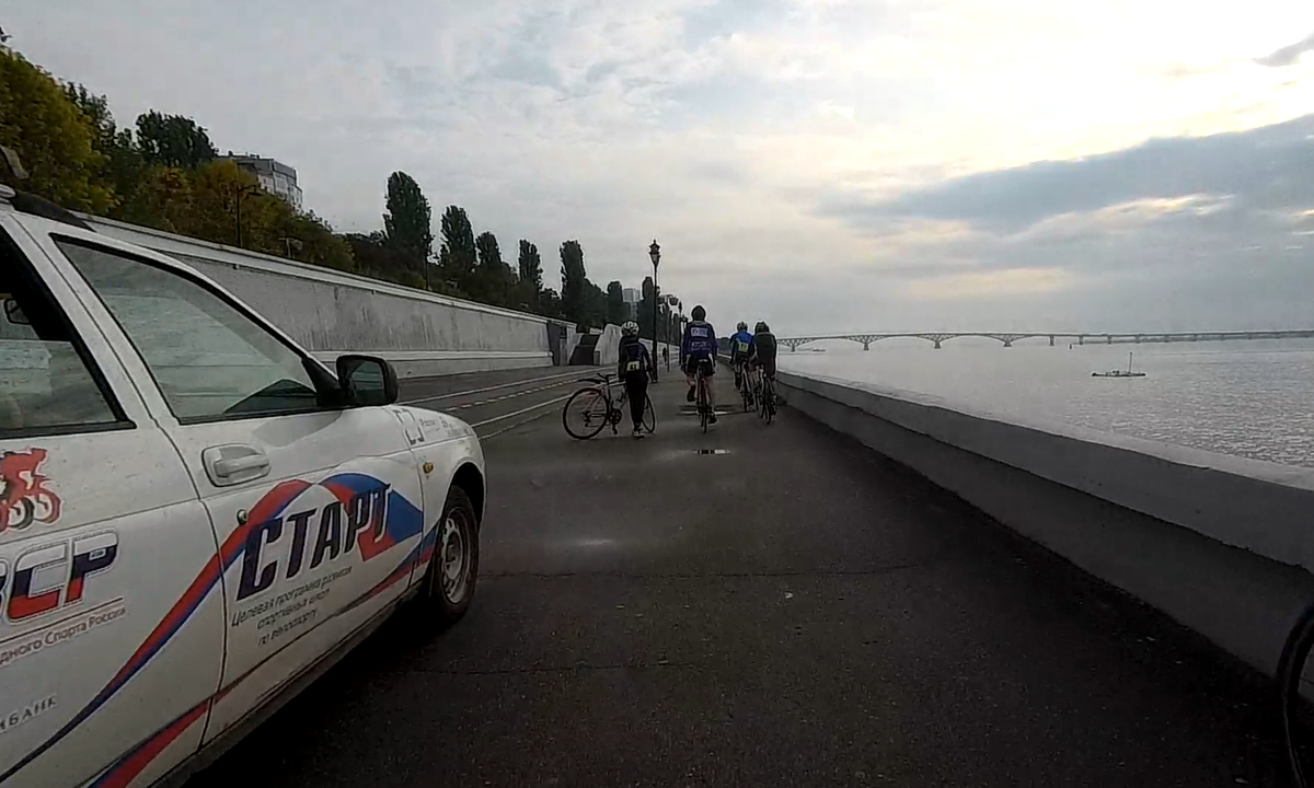 Катим по набережной. Встретили подготовку к старту каких-то вело-соревнований. Все на шоссейниках, с бритыми накачанными ногами, на контактных педалях и серьёзных щах. Собрались экипажи с нескольких регионов, всего около 50 спортсменов.  На заднем плане мост, скоро по нему поедем.
