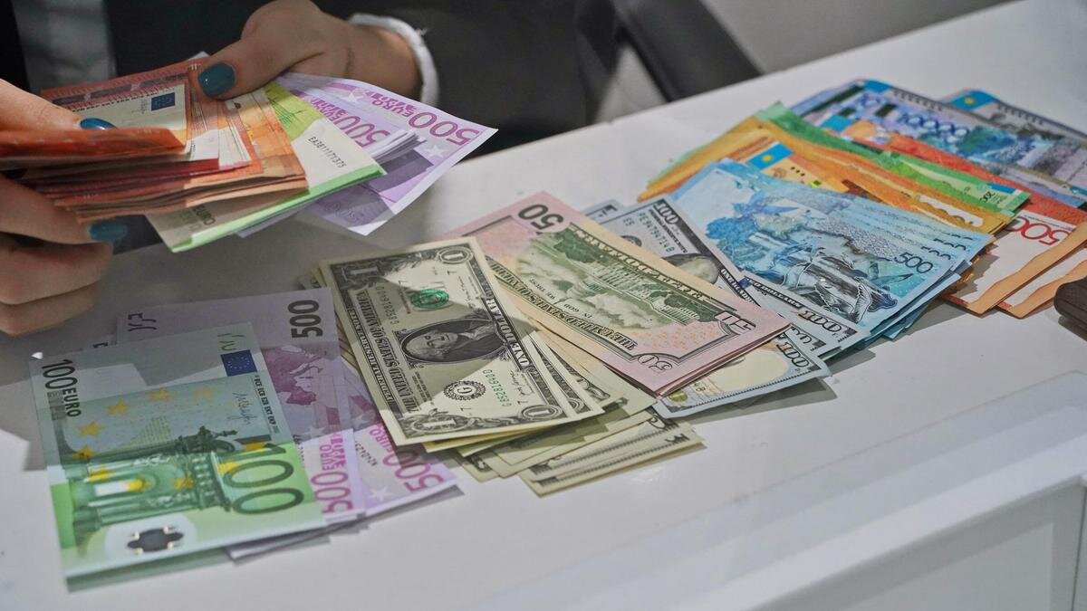    Женщина считает деньги в разной валюте:NUR.KZ/Владимир Третьяков