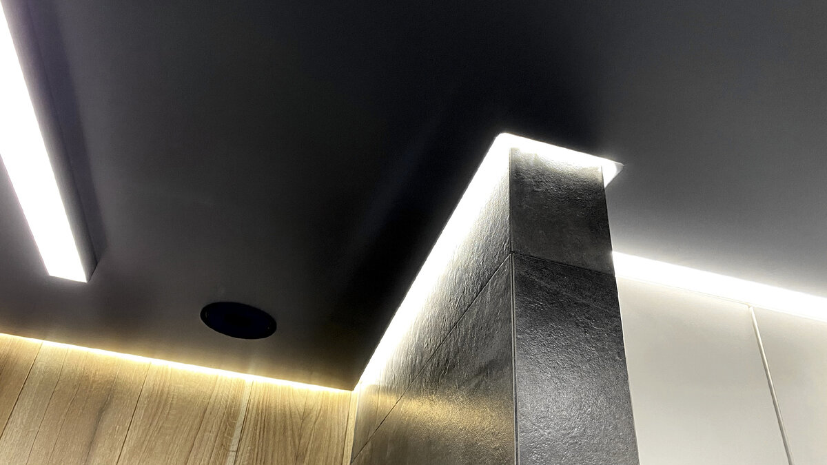 Натяжной потолок выполнен по технологии теневого примыкания - так, что между стеной и полотном есть небольшой зазор, создающий эффект парящего потолка. В этом зазоре в специальном кабель-канале и проложена светодиодная лента