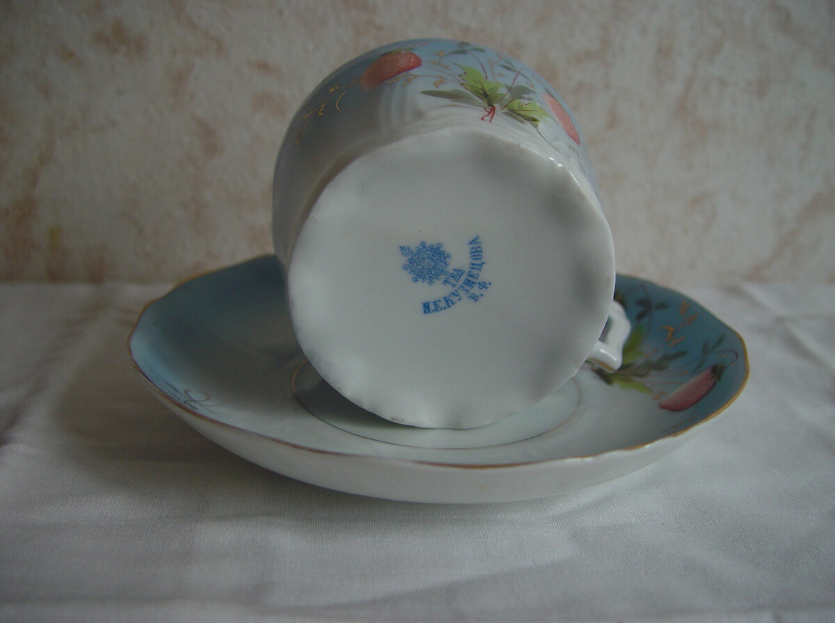 Клеймо товарищества И.Е. Кузнецова говорит о том, что такие чашечки (в стиле РУССКАЯ ЭКЛЕКТИКА), несмотря на царящий повсеместно в России в то время зрелый (и даже поздний!) АР-НУВО, легко нашли своего покупателя, в данном случае - мою бабушку. Товарищество на паях И.Е. Кузнецова было образовано в мае 1913-го года. С учётом войны, начавшейся летом 1914-го года (при том, что какой-то запас материалов на фирме оставался), эту пару можно атрибутировать не ранее мая 1913-го, и не позднее лета 1915-го.