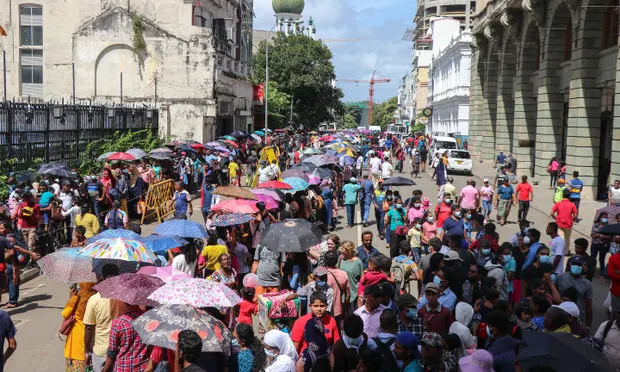 Тысячи людей выстроились в очередь, чтобы заглянуть во дворец президента в Коломбо через три дня после того, как его штурмовали протестующие. Фотография: Саман Абесивардана/Pacific Press/REX/Shutterstock.