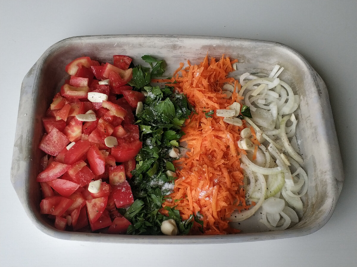 Нарезаем овощи.помидор кубиком, лук полукольцами, морковь трем на терке, зелень и чеснок мелко рубим. Кладём в форму смазанную маслом