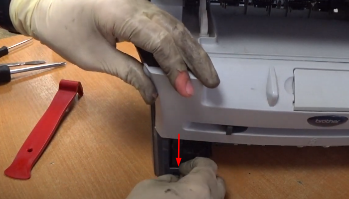 Фото 12. Снимаем белый фиксатор оси, указанный стрелкой