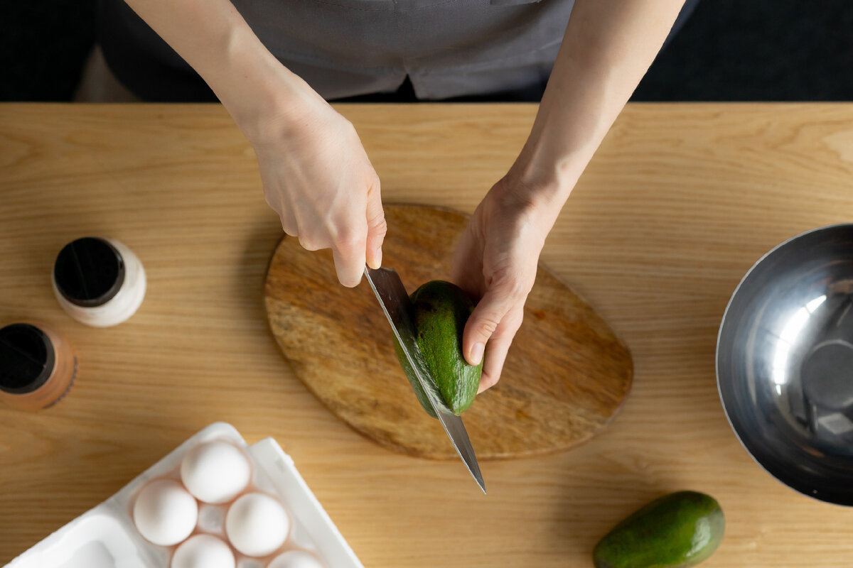 Нарезаем авокадо на кусочки, разминаем вилкой, сбрызгиваем оливковым маслом и лимонным соком, перчим (листайте карусель).