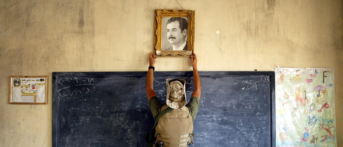 Американский морпех срывает фотографию Саддама Хусейна в школе в Аль-Куте, Ирак, 16 апреля 2003 г. (Фото: Chris Hondros/Getty Images)
