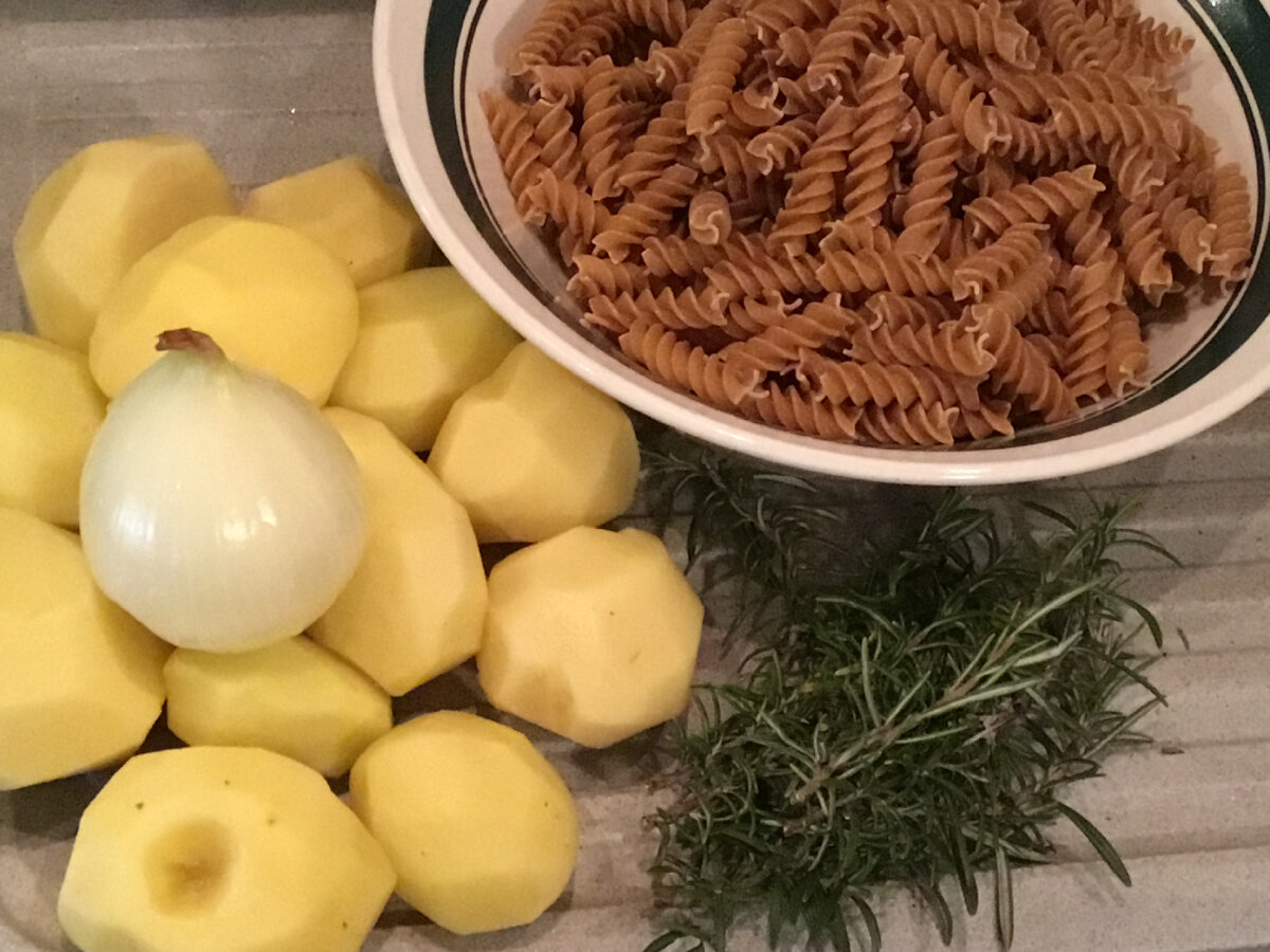 Картошка, лук, розмарин и макароны. Не хватает на фото только оливкового масла. Макароны я взяла из цельного зерна, потому они такие темные. Это мой небольшой реверанс в сторону диетологии. В классическом рецепте обычные макароны из твердых сортов пшеницы. 