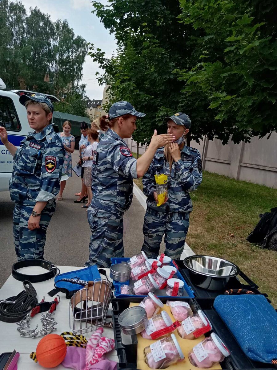 Девушки-кинологи, а на первом плане - амуниция для собак, игрушки и банки с различными вариантами запахов.