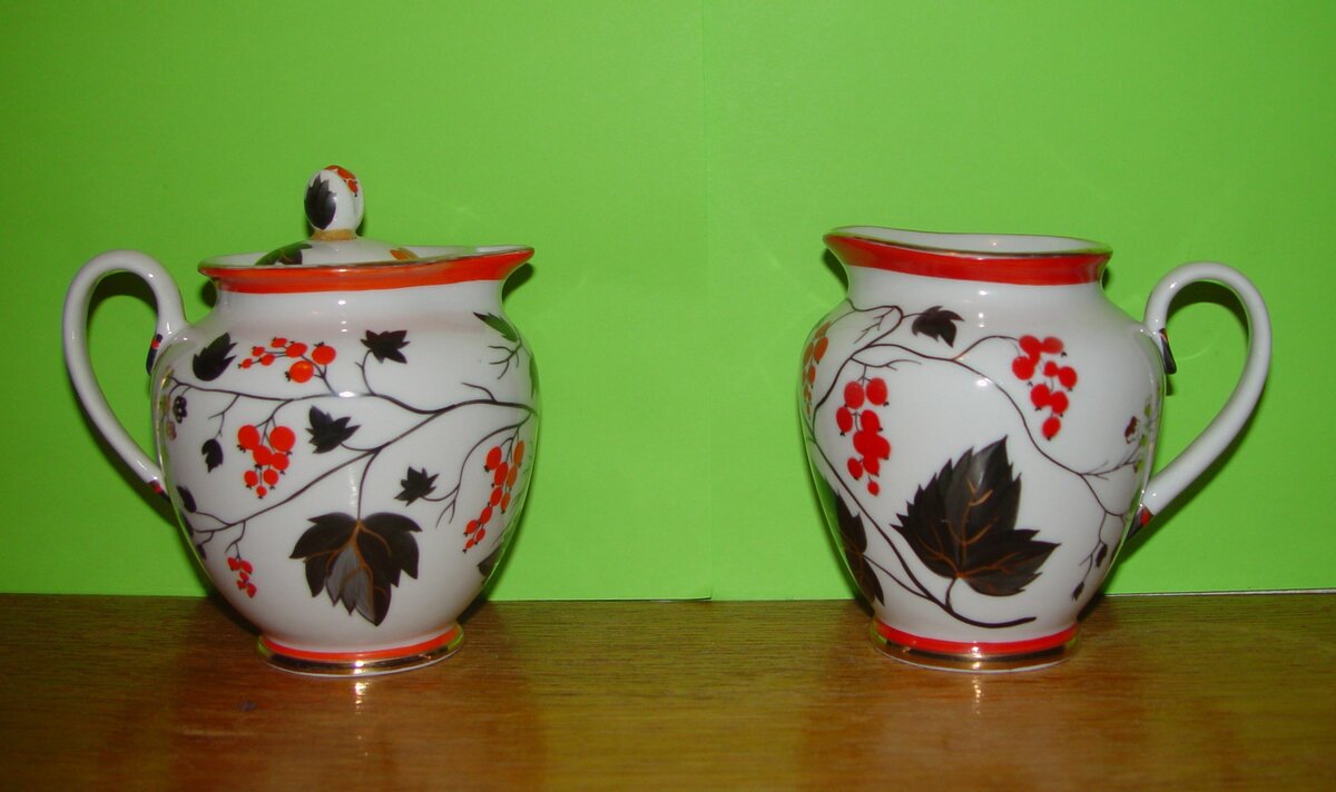 Сервиз "Красная смородина". Разница в молочнике для сервиза формы "Весенний" (сейчас он одинаков и для кофейного, и для чайного вариантов).  Во-первых, в сравнении с ранним выпуском (начала 1950-х гг., тот, что слева), молочник справа "похудел". Носик выражен, но не столь чётко. Нет крышки. Испарилась и полочка в виде кольца для крышки. Особенно хорошо это видно на следующем фото.
