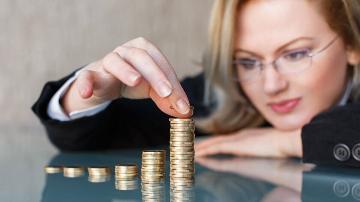    Бизнесвумен строит башню из монет© Fotolia / sakkmesterke