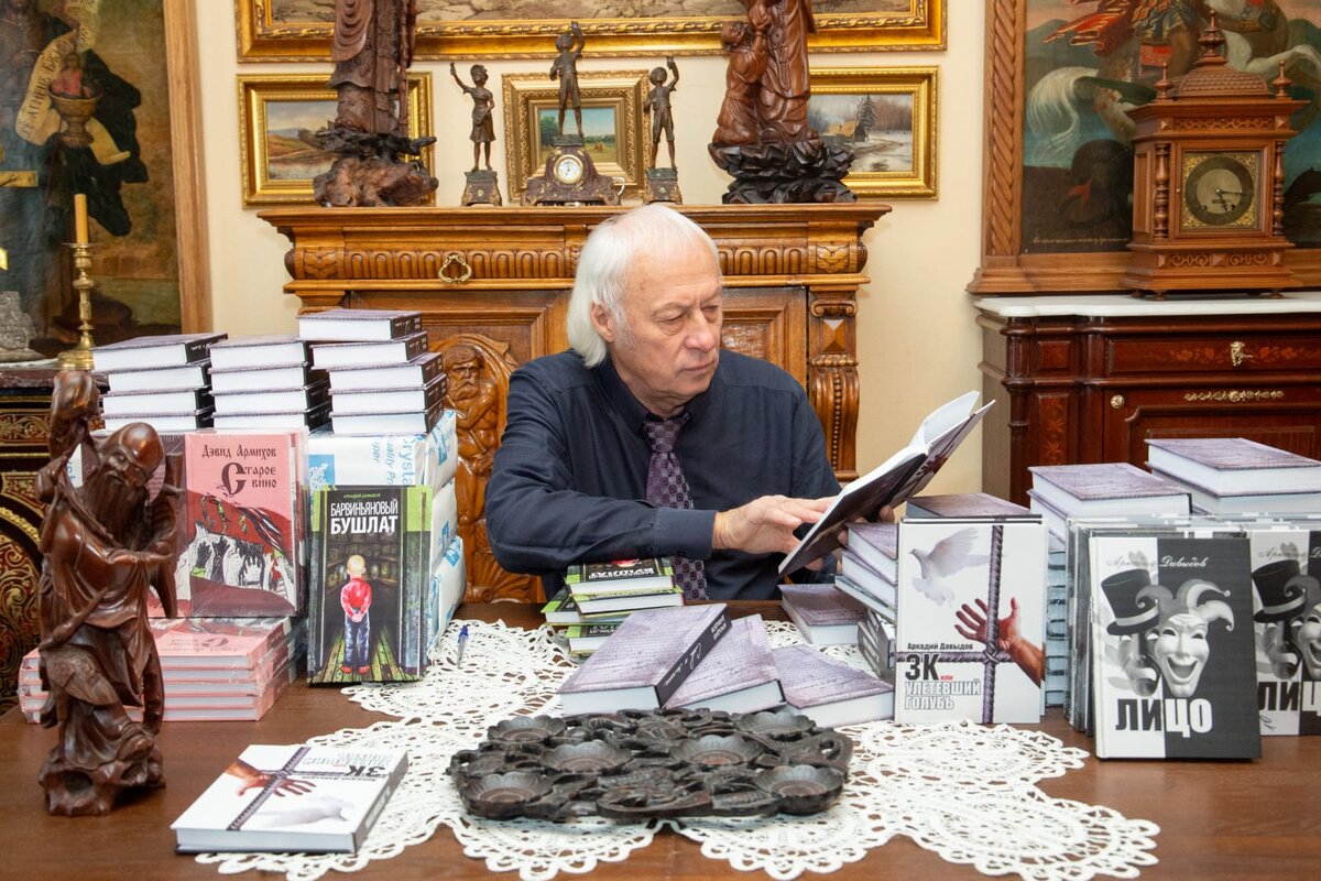 Аркадий Давыдов за рабочим столом, разбирает тираж только что изданных книг  