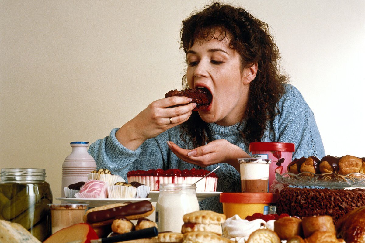 Повышение голода. Переедание. Обжорство. Женщина много ест. Пищевые привычки.