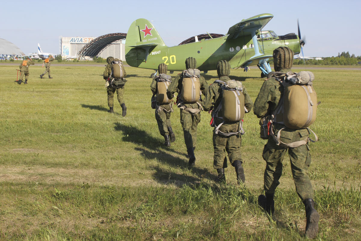 Группа парашютистов десантников бежит в самолет Ан-2 для совершения прыжка. 