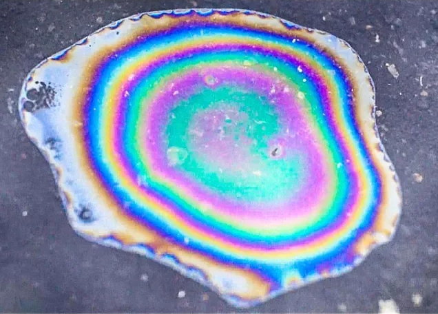 капля бензина растеклась на поверхности воды