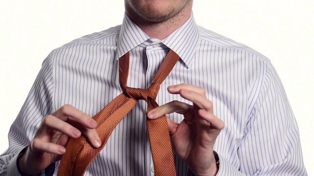 Мужчина завязывает галстук. Фото из Интернета.