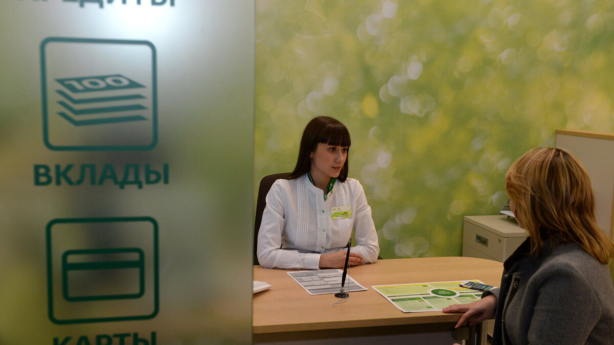    " Клиент в кредитном отделе офиса Сбербанка© РИА Новости . Максим Богодвид