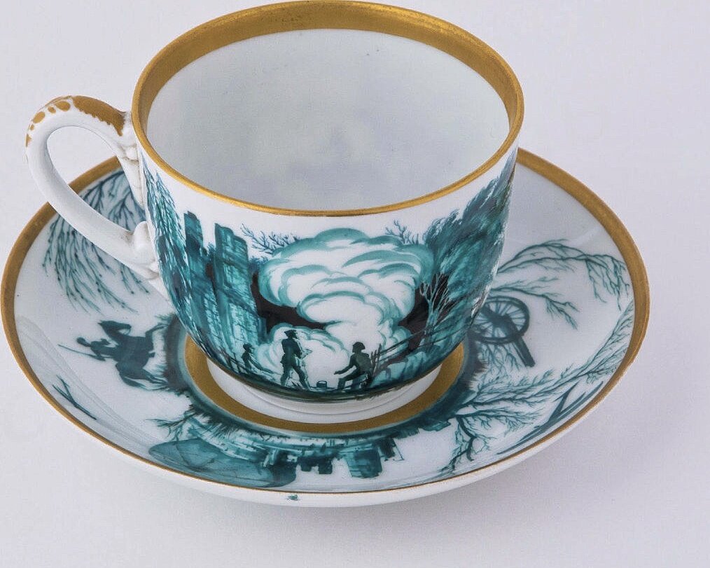 Чайная пара с изображением красноармейцев, аэропланов, пушки, дирижабля. Государственный фарфоровый завод. М.М. Адамович. 1923 год. Эстимейт 1295000 - 1350000 рублей, источник https://ru.bidspirit.com/