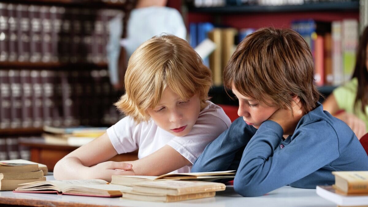    Школьники читают книги в библиотеке© Fotolia / Tyler Olson