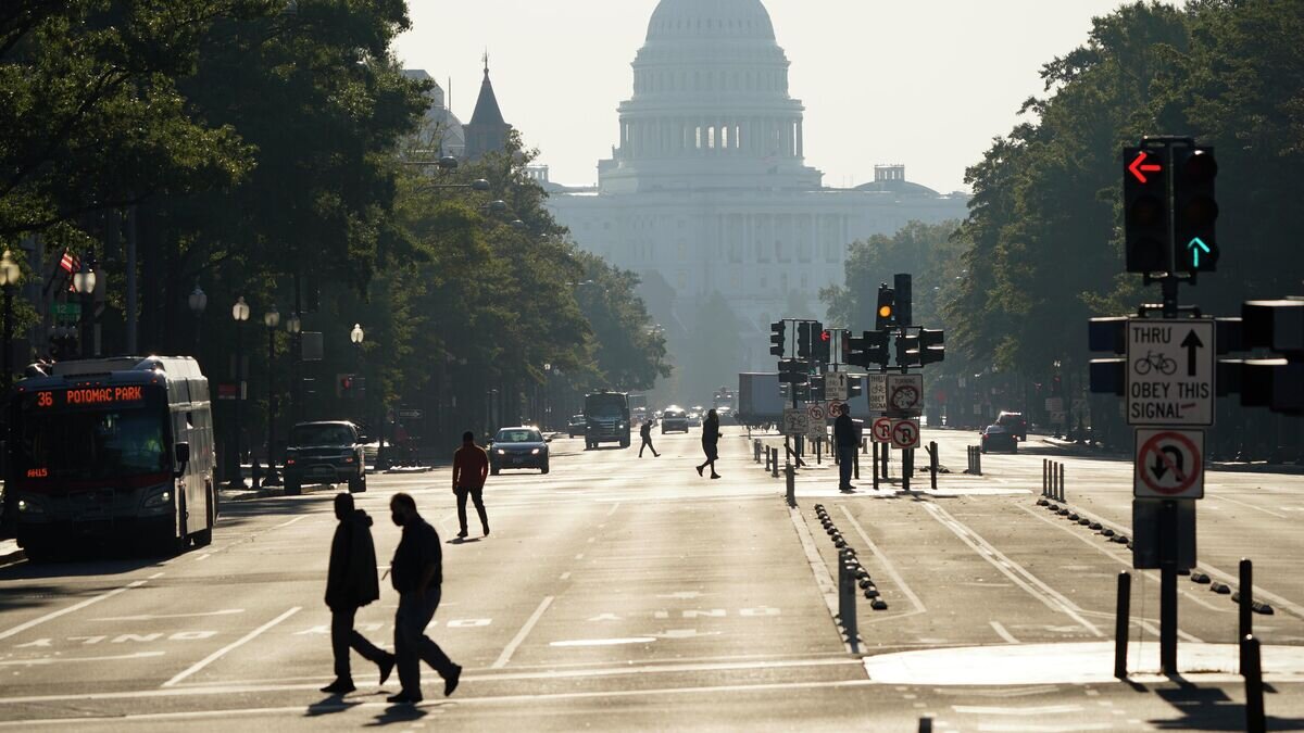    Прохожие переходят улицу перед зданием Капитолия в США© AP Photo / J. Scott Applewhite