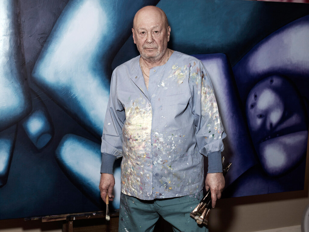 Олег Целков на фоне одной из своих картин