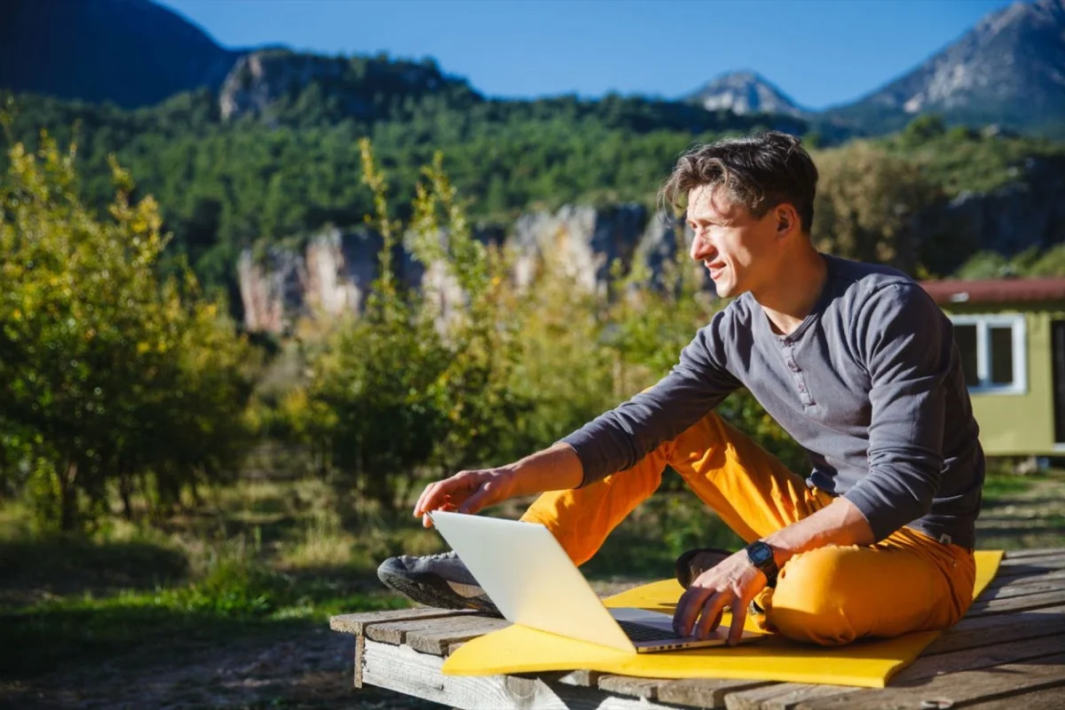 Ноутбук на природе. Фрилансер на природе. Мужчина с ноутбуком на природе. Бизнесмен на отдыхе.