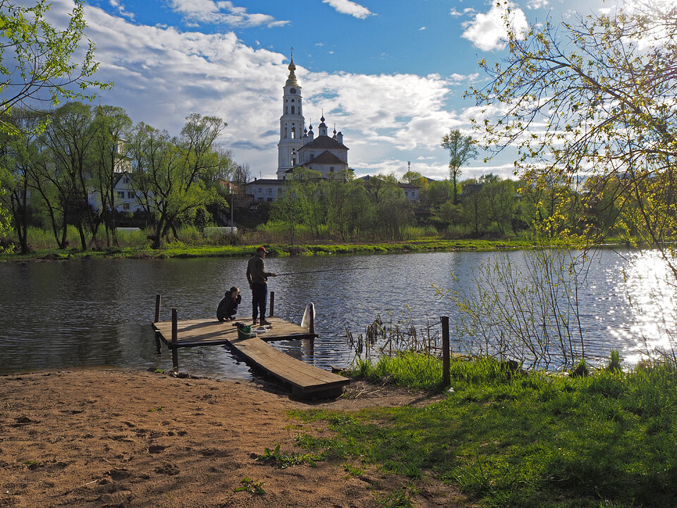 Папа с сыном ловят рыбу.