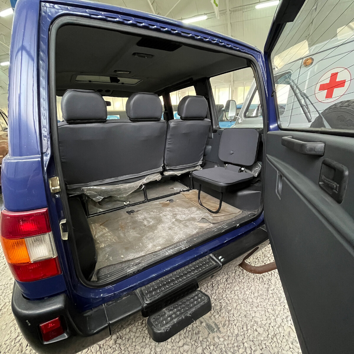 В багажнике есть 2 складных кресла для ещё двух пассажиров. Для удобной посадки на двери багажника предусмотрена ручка, а под бампером дополнительная ступенька.