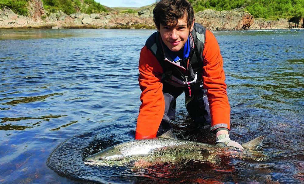 Рыболов в семгой в руках 