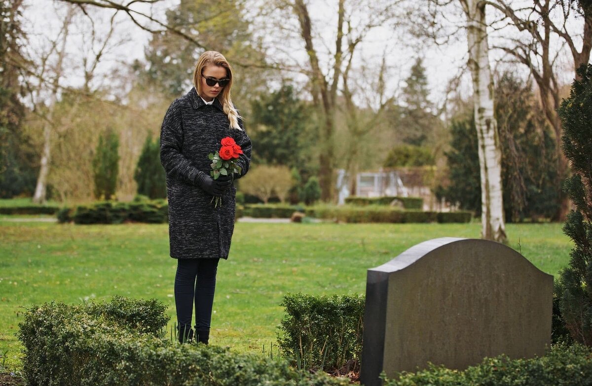 Девушка с цветами у могилы