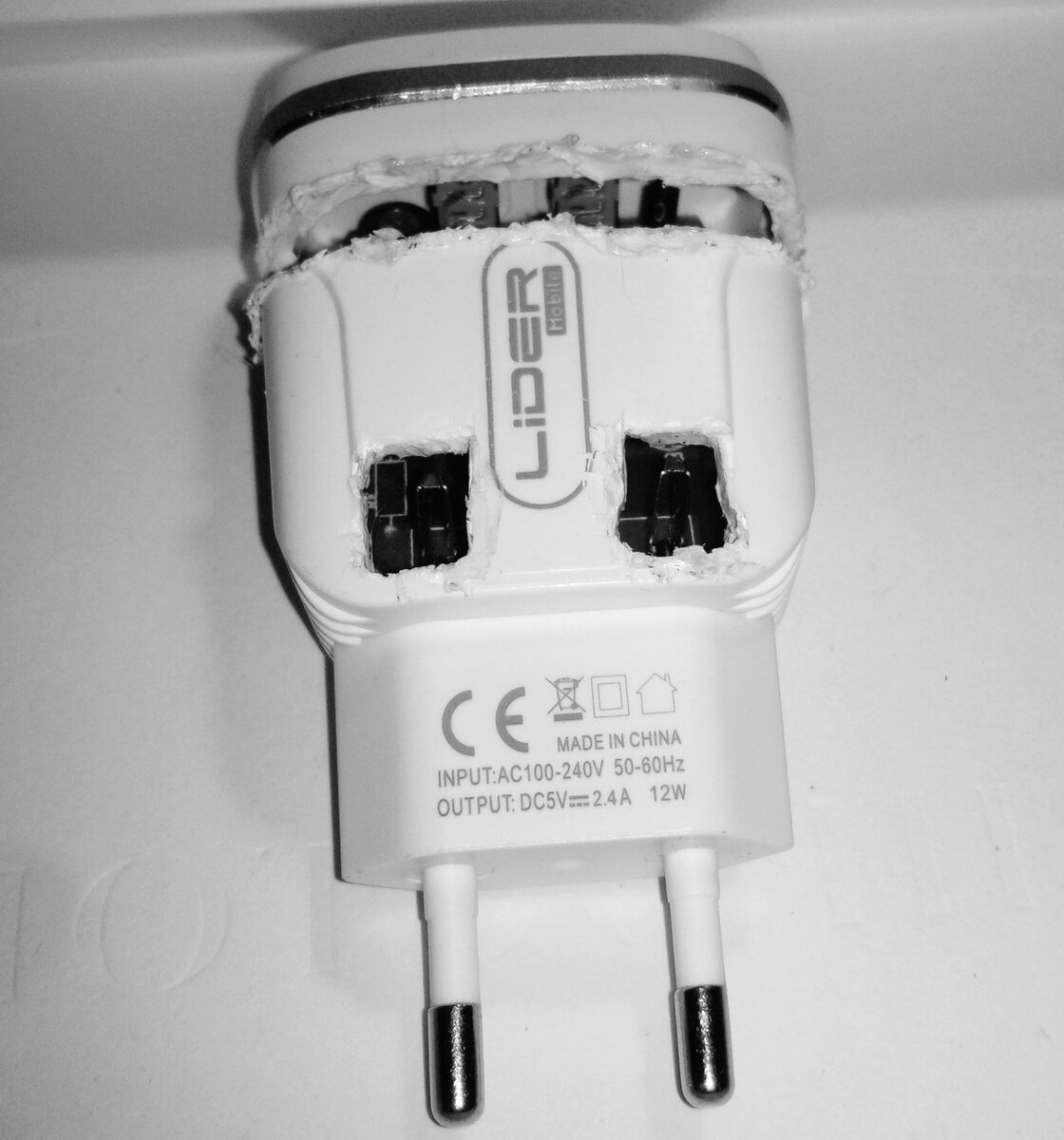 Купил в магазине зарядку для телефона с двумя выходами USB. Проверил-работает, идет заряд...Убрал в коробку к остальным зарядкам...Спустя какое-то время решил замерить сколько вольт выдает... Вынул из коробки и что-то внутри загремело...Подумал трансформатор судя по весу... Менять идти лениво, думаю открою, посмотрю и припаяю, если ничего серьезного... А нет-так выкину,180 рублей не повод, чтобы удавиться)))... Открыть не получилось, швов нет, залито прочно...Разрезал выжигателем (пластик прочный и толстый,видать не хотят , чтобы потребители узнали причину поломки) и охренел...