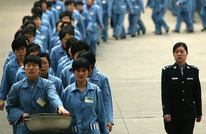 Заключённые идут рядом с полицейским конвоем во время дня открытых дверей в тюрьме в Нанкине, 2005 год. (STR/AFP/Getty Images) 