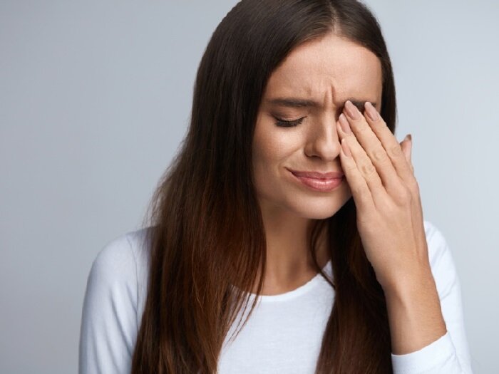 Фото Девушка нажимает на глаза руками.