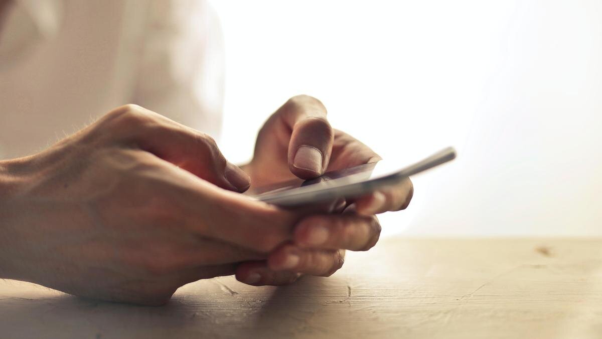    Человек держит в руках смартфон:pexels.com