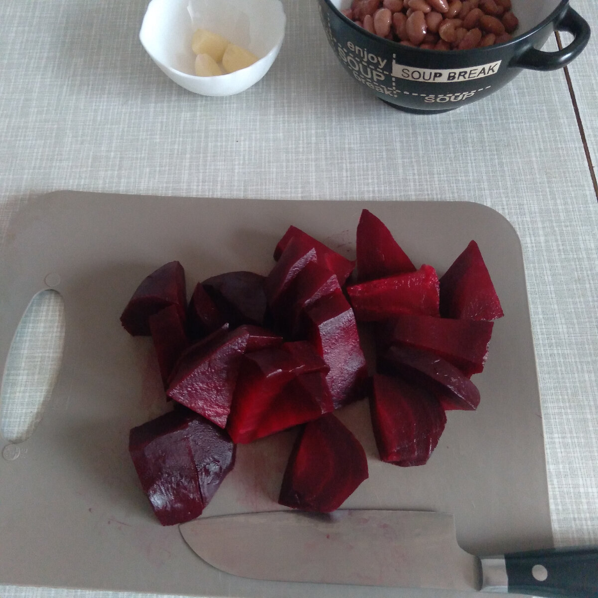 Свеклу порезать на кусочки. С фасоли слить жидкость. Чеснок выдавить через чеснокодавку. 