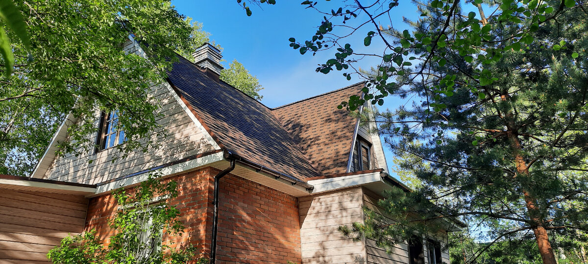 Вот такая, более сложная, форма крыши. При этом второй этаж не является жилой мансардой, это просто чердак и изначально таким и планировался. Здесь же видно, что часть дома, которая зашита сайдингом выступает от кирпичной стены на значительное расстояние. Фото Наталья Панфилова.

