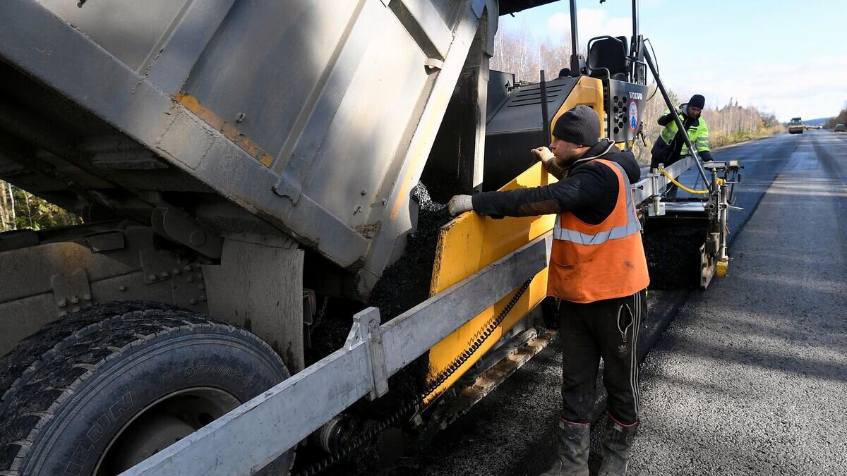    Сотрудники ООО "КДСК" укладывают новый асфальт© РИА Новости / Илья Наймушин