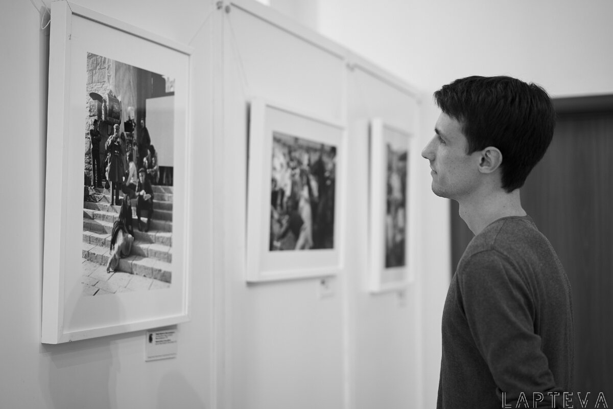 Брат в краеведческом музее рассматривает фото выставку.