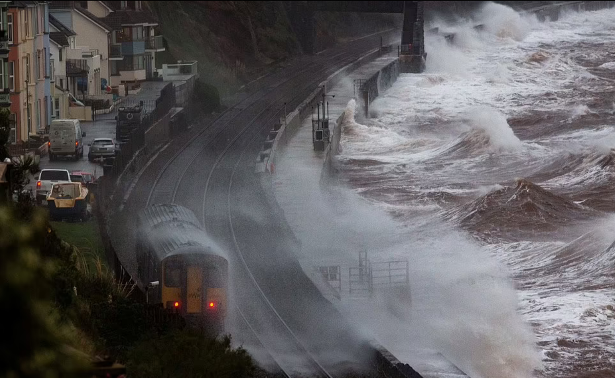 Поезд движется по набережной в Долиш в Девоне этим утром, когда Шторм Барра приближается к Британии.
