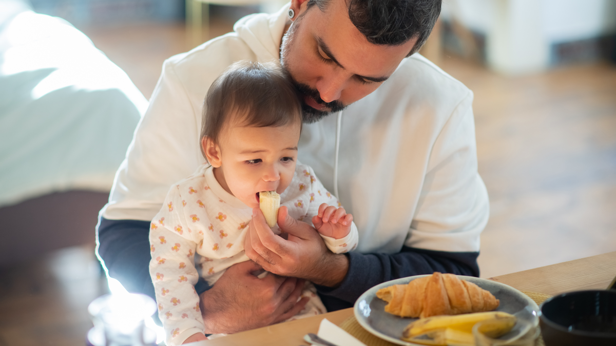 Feeding dad. Мужчина кормит младенца. Мужчина врач кормит ребенка с ложки.