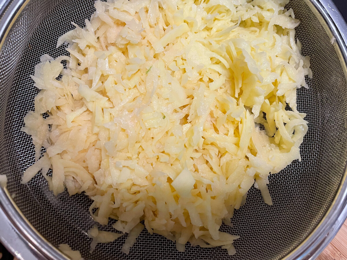 Натираем картофель и отжимаем с помощью сита