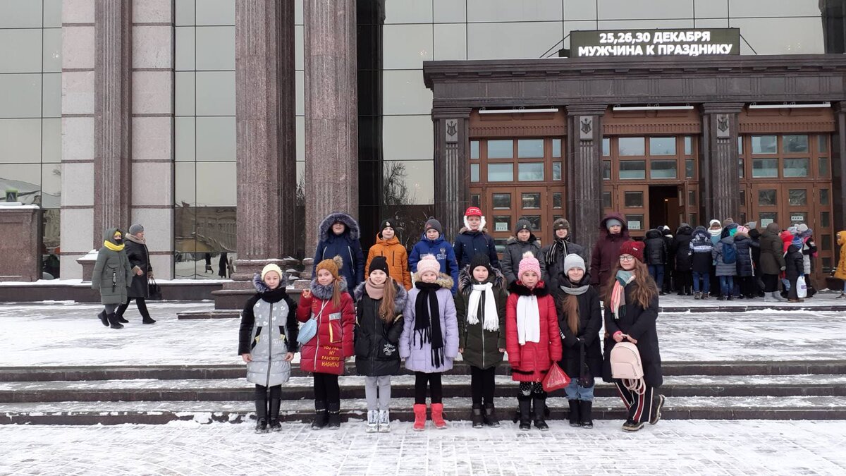 Моя в центре в розовых сапогах и фиолетовой куртке