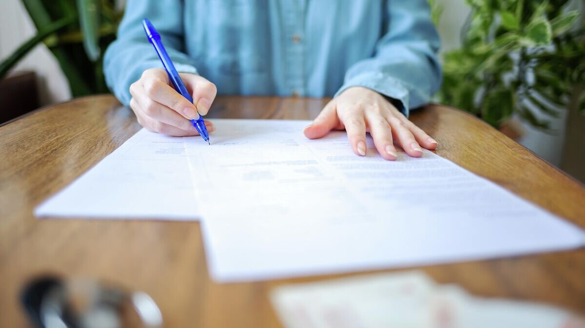    Женщина подписывает документы © Depositphotos / Steklo_KRD