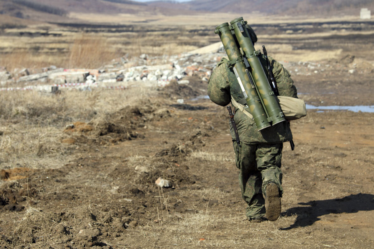 Огнеметчик бежит на позицию для стрельбы, вооружен огнеметом Шмель (два контейнера - два выстрела термобарической гранатой)