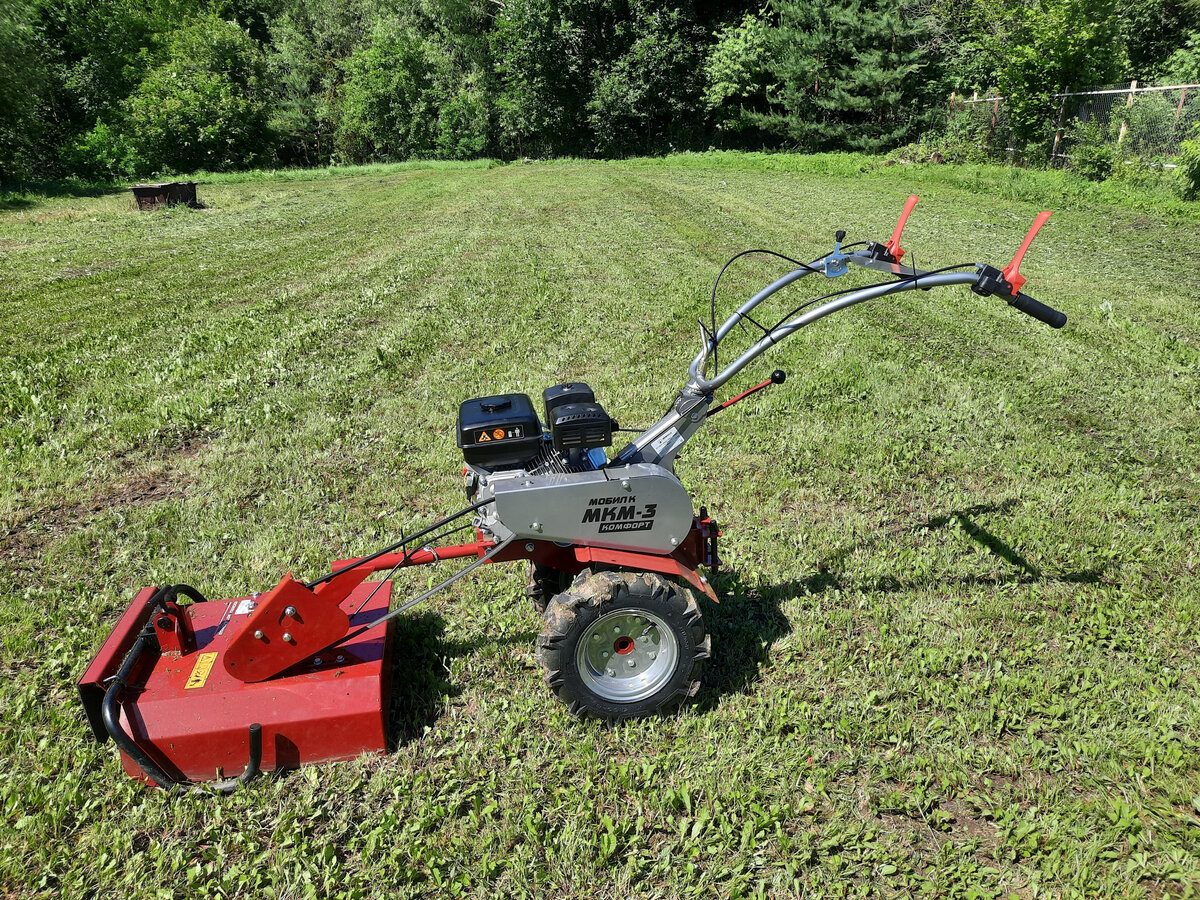 Мотоблок с закрепленной на него косилкой и результаты покоса.