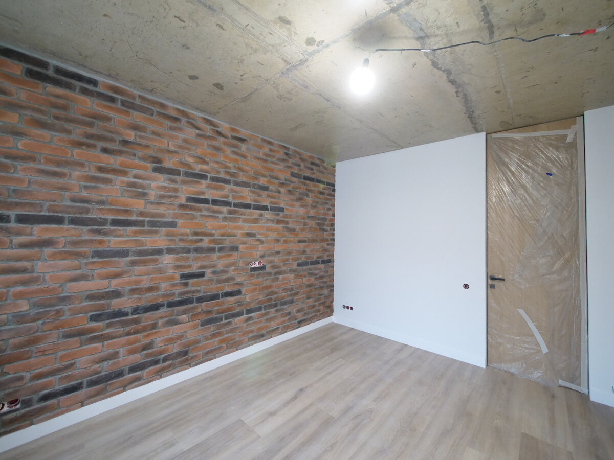 Лофт, хотя выходит из моды, остается самым прагматичным вариантом. Без отделки в квартире можно оставить не только стены, но и потолки.