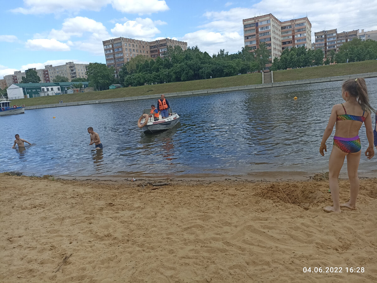 Спасатели велят парням покинуть реку.