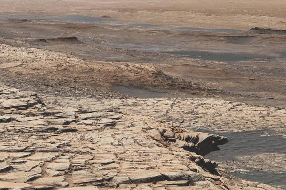     Марсианская поверхность, из-под которой "Любопытство" высверлил отложения, богатые изотопом углерода.
